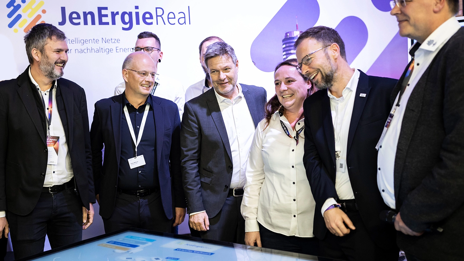 Ein begeisterter Bundeswirtschaftsminister Robert Habeck (Mitte) am Stand der Stadtwerke Jena zum Digital-Gipfel der Bundesregierung: In ihrem Reallabor JenErgieReal zeigen die Stadtwerke, wie mittels Digitalisierung die Energiewende in Städten gelingen kann. Mittels intelligenter Steuerung konnten im Vorprojekt Smartes Quartier Jena-Lobeda bereits 30 Prozent Energieeinsparung erreicht werden. ©BMWK_bundesfoto Christina Czybik